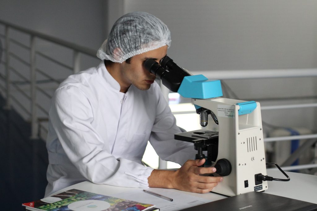 lab researcher looking in microscope