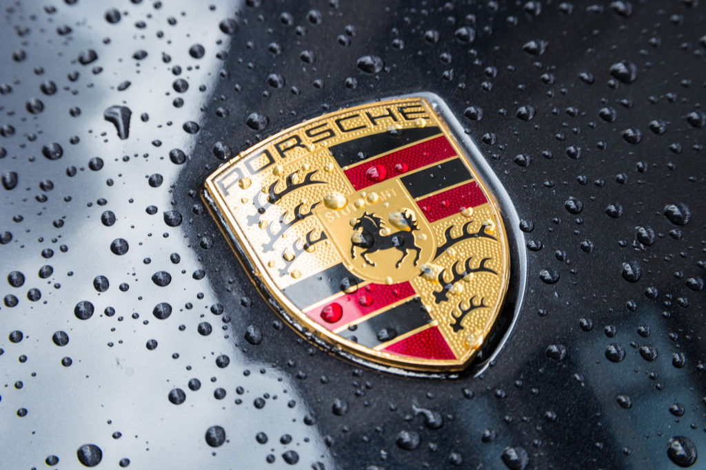 A large logo on the hood of a Porsche.