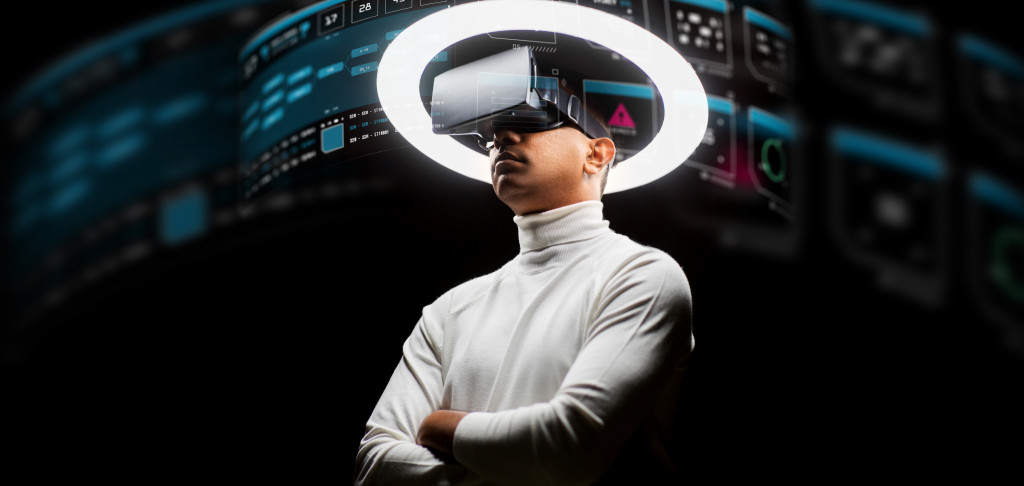 Man using a virtual reality headset with a black background and illuminated circle above him.